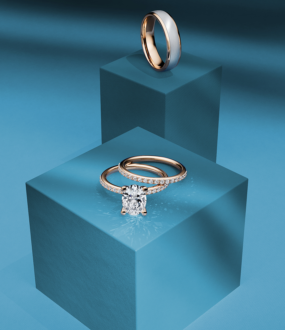 Birks diamond engagement ring and wedding band on a blue background
